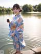 A woman in a blue kimono holding a cup of coffee.