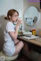 A woman sitting at a desk with a cup of coffee.