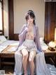 A woman in a kimono sitting on a bed.