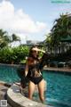 A woman in a black bathing suit standing in a pool.