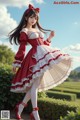 A woman in a red and white dress is posing for a picture.