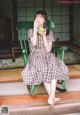 A woman sitting in a rocking chair eating a piece of fruit.