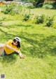 A woman laying on the grass in a field.