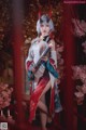 A woman dressed in a kimono holding a sword in front of flowers.
