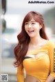 A woman in a yellow shirt posing for a picture.