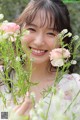 A woman holding a bunch of flowers in her hands.