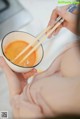 A woman holding a bowl of soup with chopsticks in it.