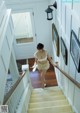 A woman walking up a set of stairs in a house.